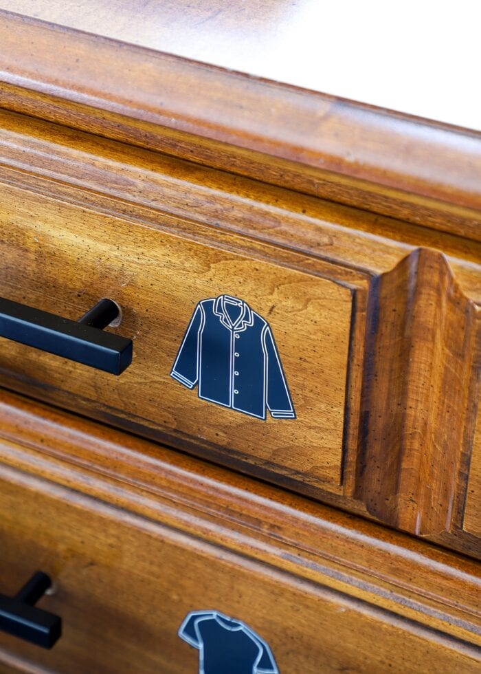 Close-up shot of a pajama dresser drawer label on a brown dresser