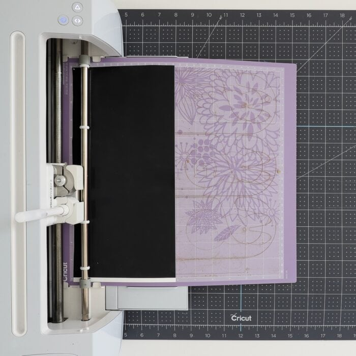 Cricut Maker 3 loaded with a purple cutting mad and Smart Label Writable Vinyl