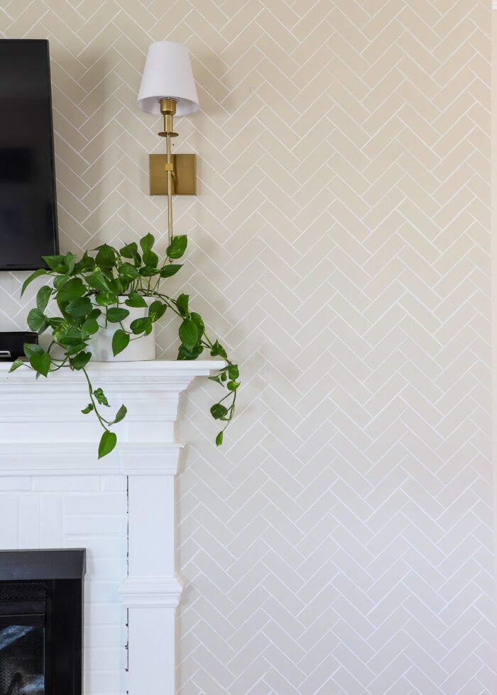 Beige wall with a white herringbone tile pattern stenciled on it