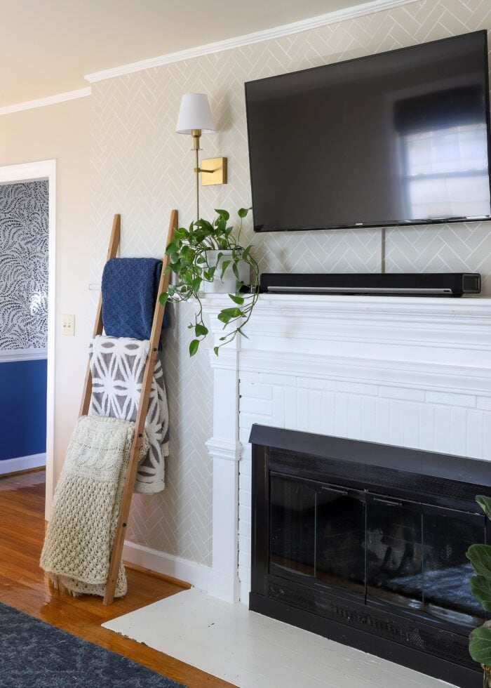 Fireplace wall with tv mounted and herringbone stencil pattern on wall