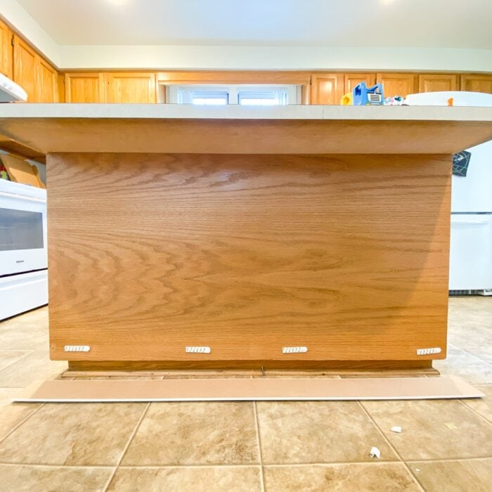 Command strips adhered to the front of a kitchen island