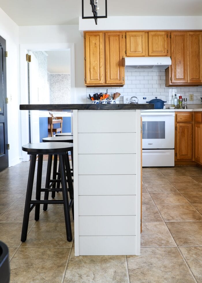 Side view of kitchen island covered in white shiplap