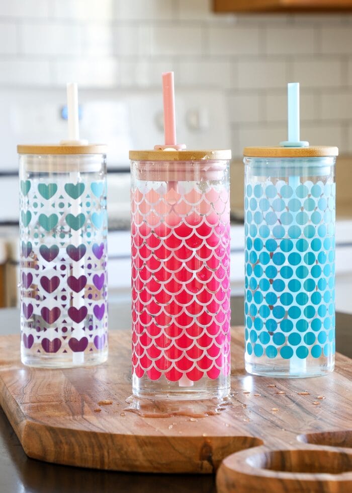 Glass water bottles covered in patterns made with Cricut Color Changing Vinyl