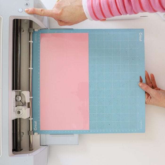 Pink Color Changing Vinyl on a blue cutting mat being loaded into Cricut machine