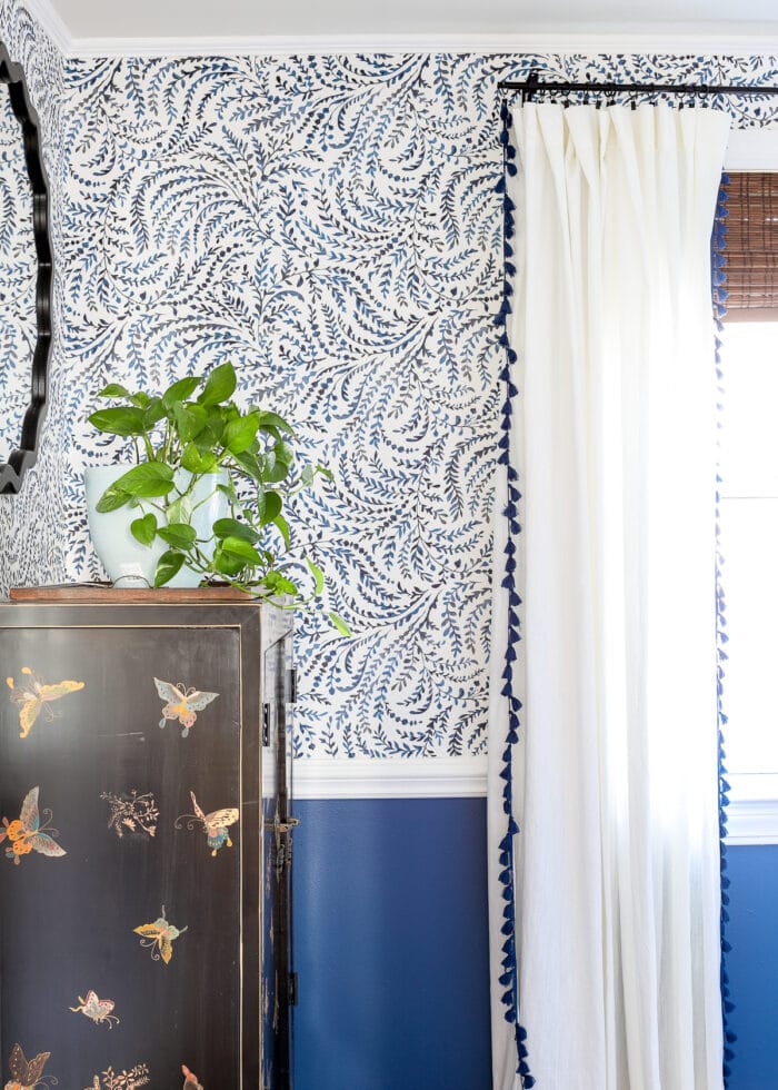 Blue and white dining room with floral wallpaper and white curtains