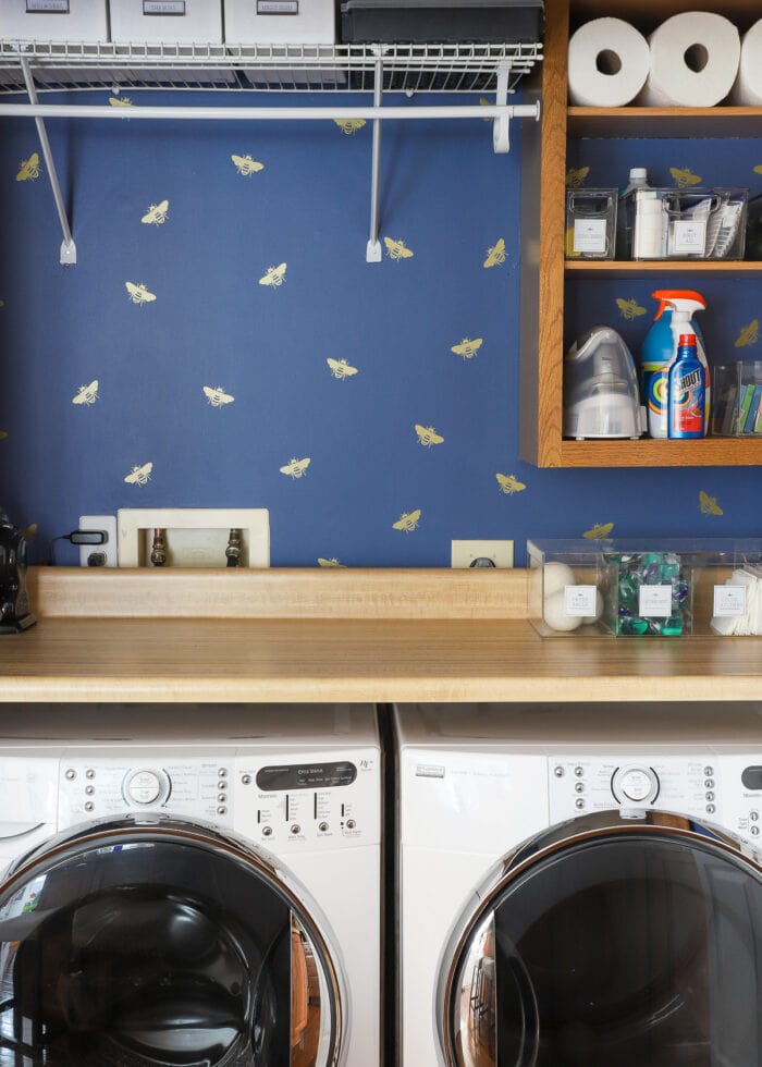 Laundry closet with blue wall covered in gold butterfly decals