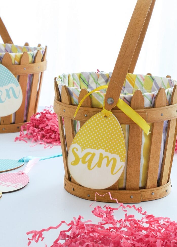 Yellow egg-shaped wooden name tag tied onto brown Easter baskets