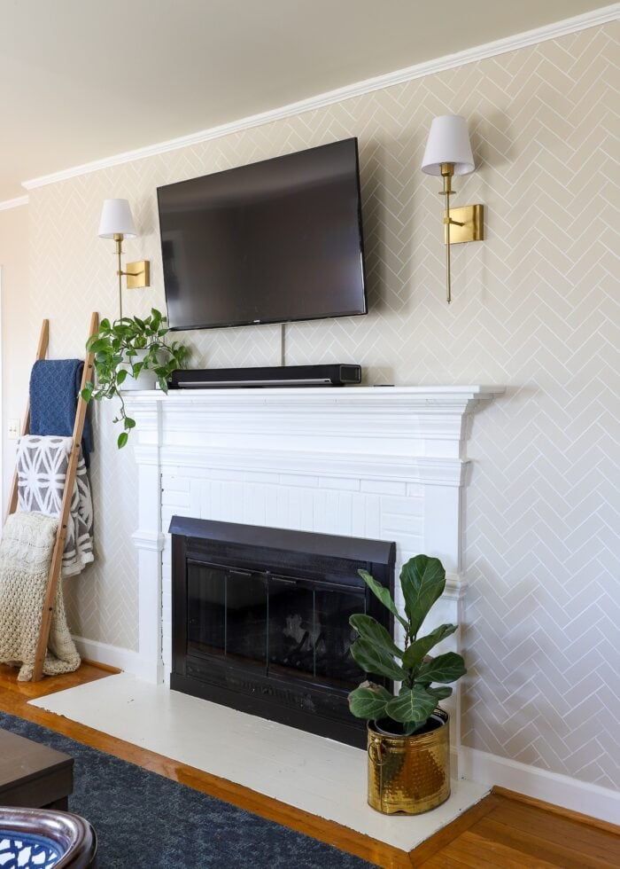 Fireplace wall in a rental with battery-operated wall sconces mounted next to TV