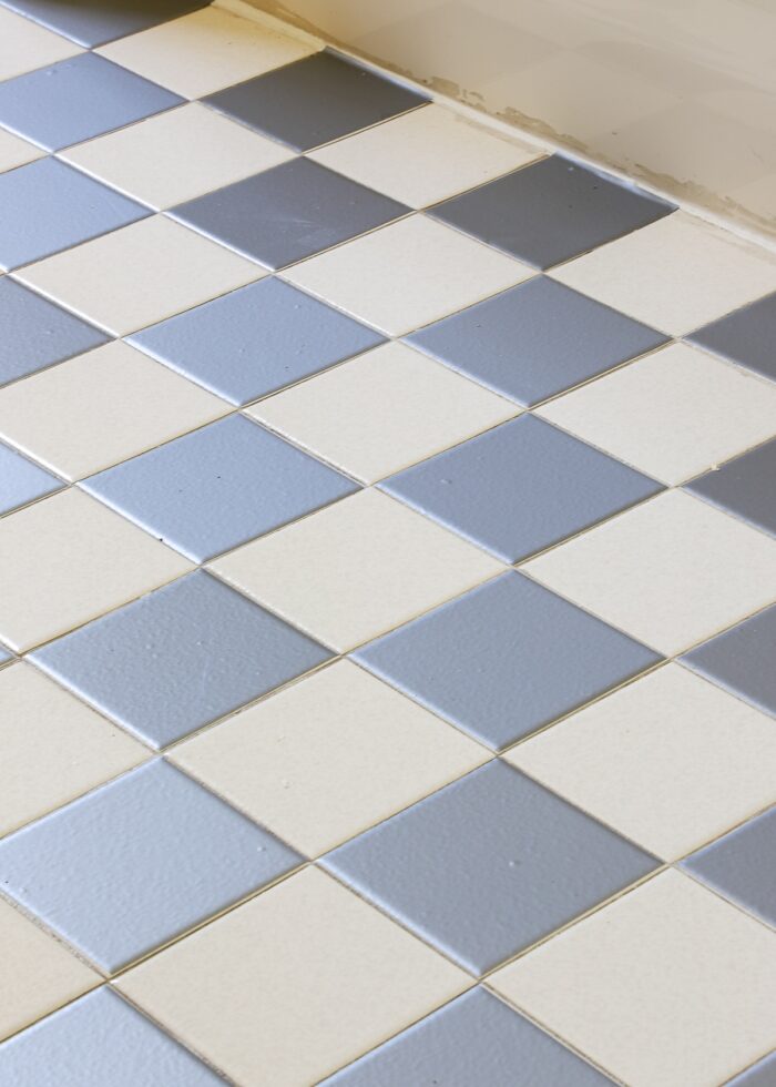 Grey vinyl tile stickers in checkerboard pattern on bathroom floor