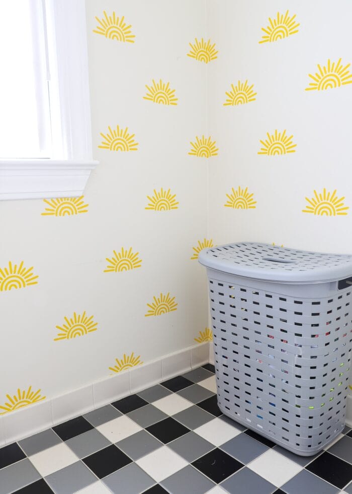 Rental bathroom with black and white buffalo plaid floors and sunshine feature wall