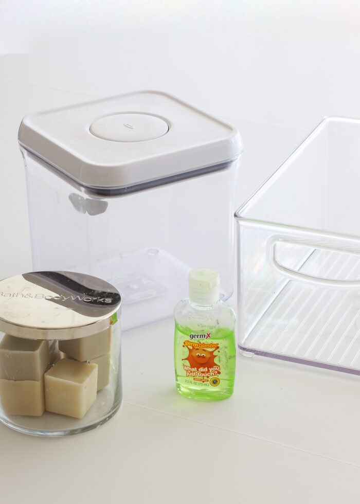 Various glass and plastic containers shown alongside a bottle of green hand sanitizer to remove glue