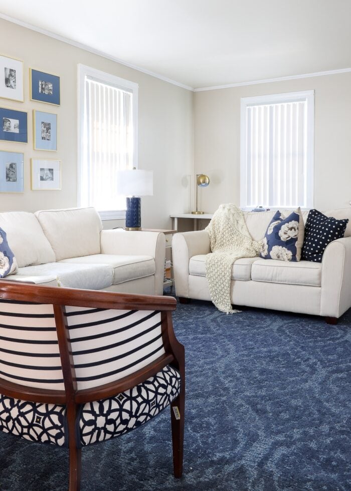 Navy and white family room with white vertical blinds on the windows