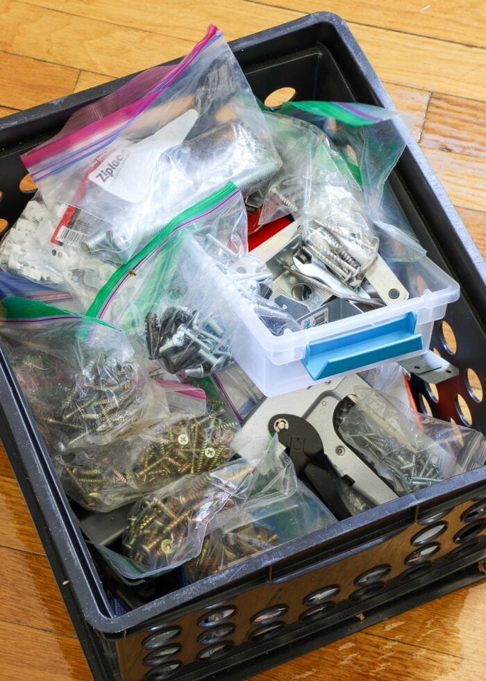 Tons of baggies holding nails and screws stuffed into a black crate