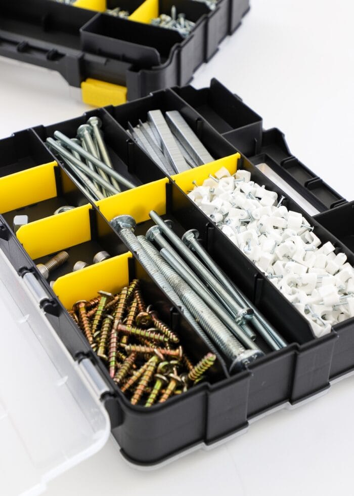 organized nails and screws in a black and yellow compartmentalized caddy