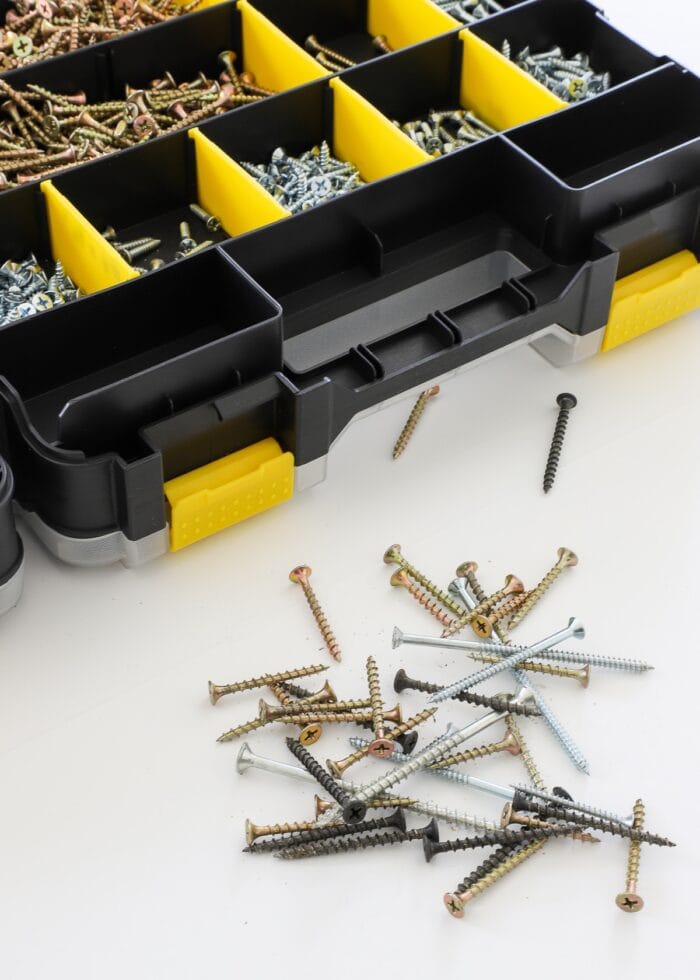 Pile of mixed up screws alongside a hardware organizer