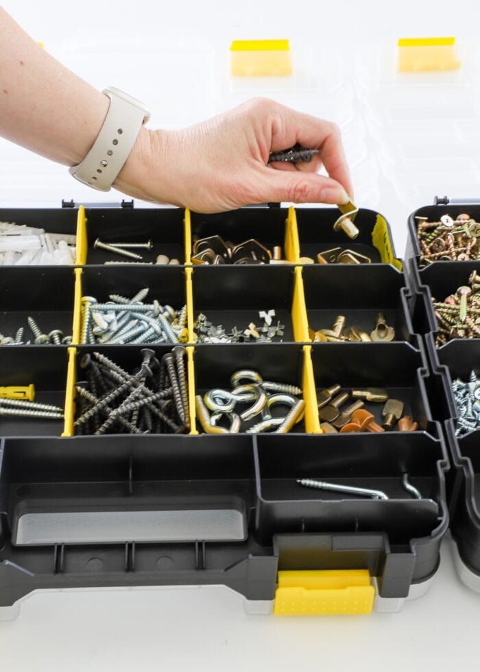 Hand sorting a peg into a hardware storage box