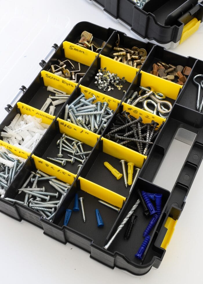 organized nails and screws in a black and yellow compartmentalized caddy
