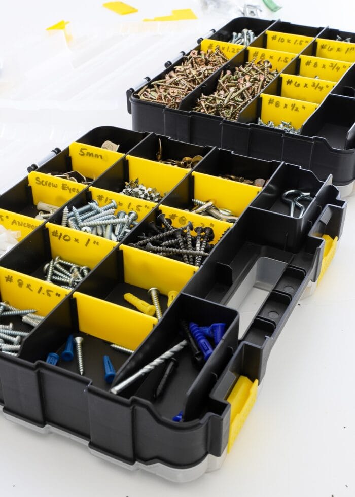 organized nails and screws in a black and yellow compartmentalized caddies