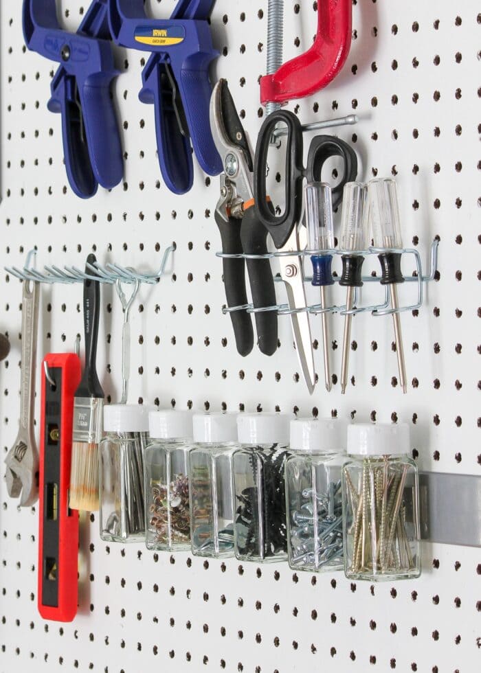 Pegboard with various tools and jars holding hardware