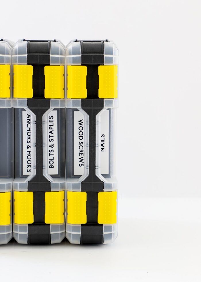 Black and yellow hardware organizers standing up in a row on a white table