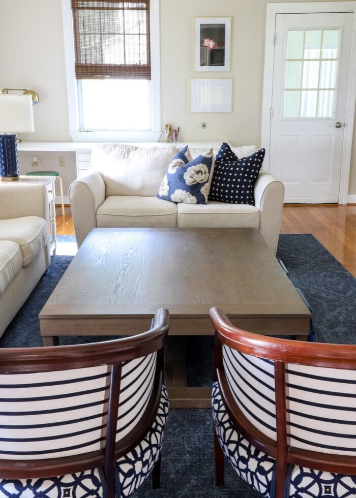 Large coffee table positioned between two couches and two decorative chairs