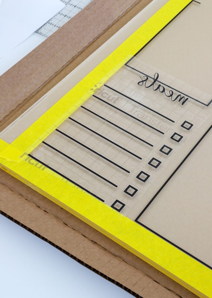 Yellow tape lines on an acrylic meal planning board