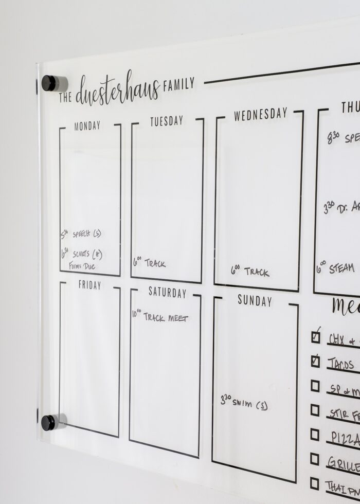 Acrylic wall calendar board filled out with dry-erase marker
