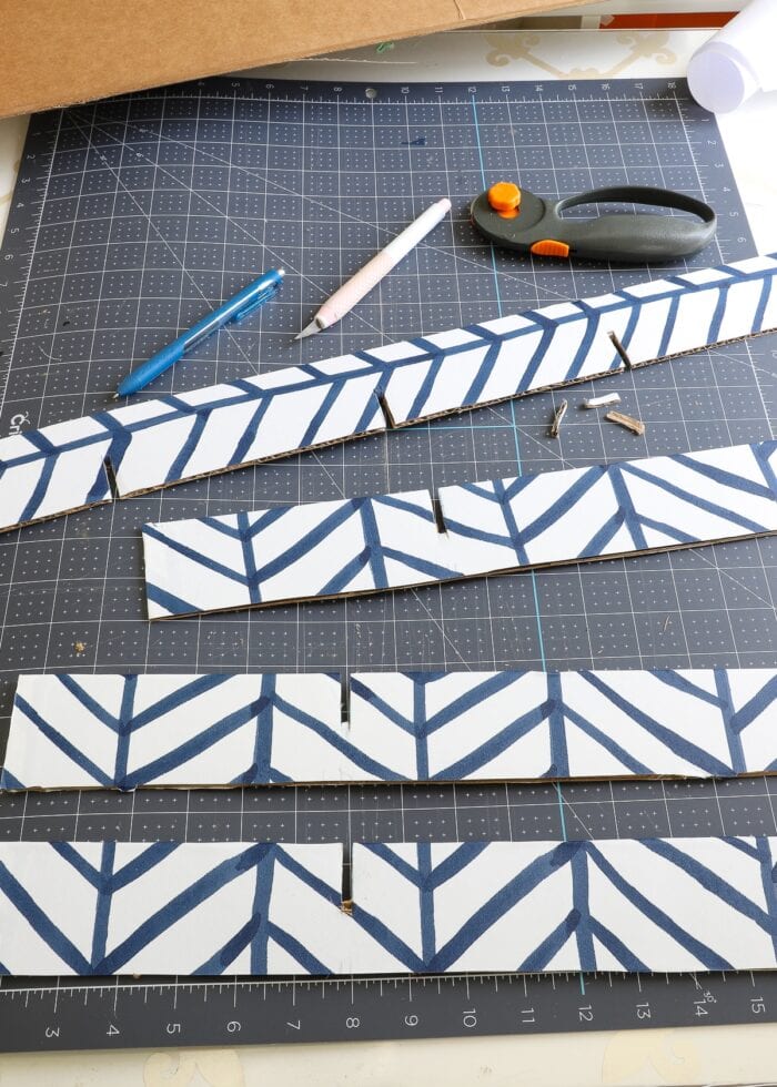 Pieces of interlocking DIY drawer dividers cut from cardboard and covered in blue and white wallpaper