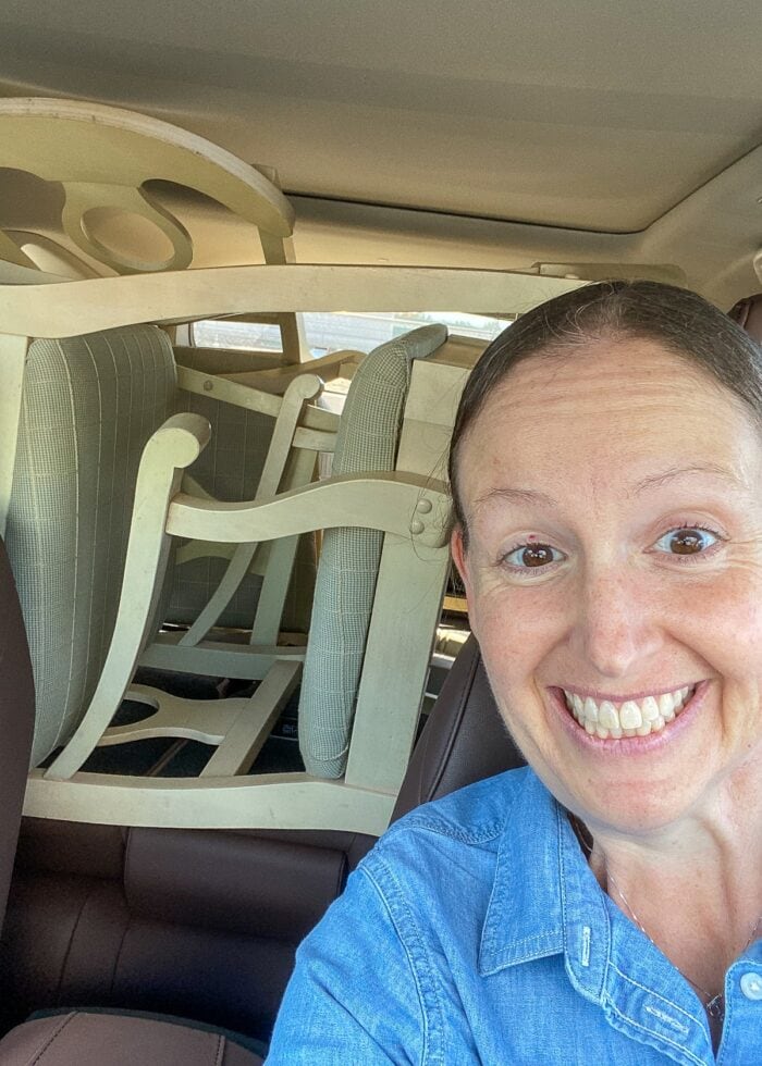 Megan with thrifted dining chairs in a car