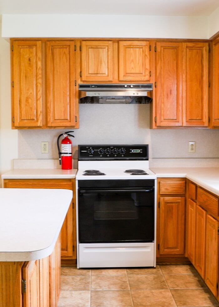 Builder-grade rental kitchen with honey oak cabinets