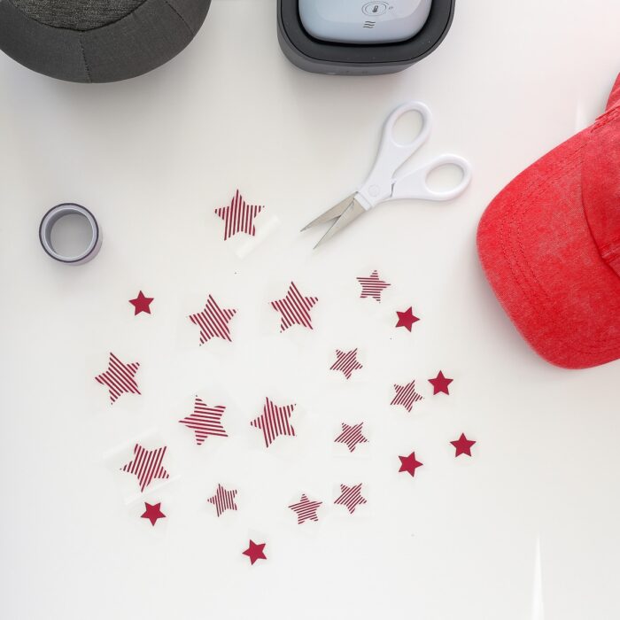 Stars cut from red iron-on vinyl on top of a white table