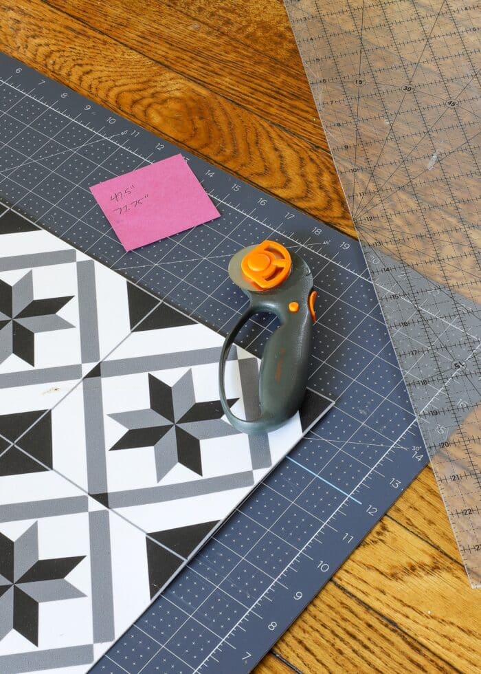 Vinyl floor mat shown with rotary cutter, acrylic ruler, and cutting mat
