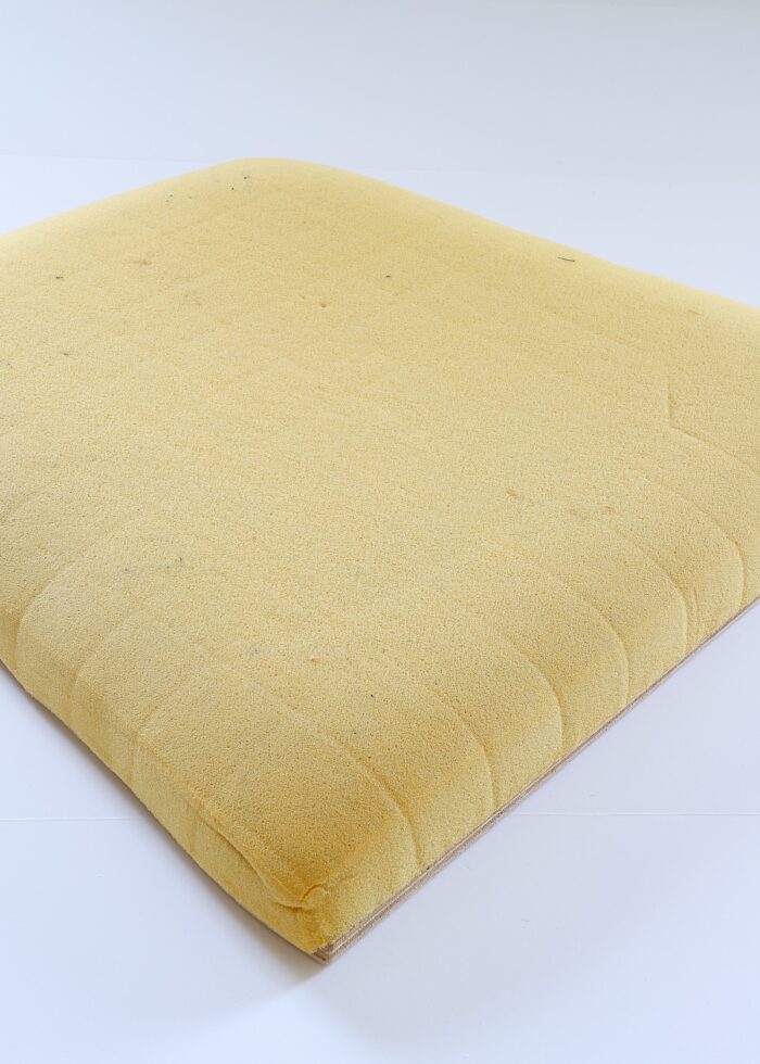 Old, discolored, compressed foam cushion from a dining room chair