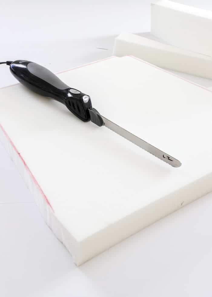 Electronic cutting knife shown on top of newly cut foam cushion