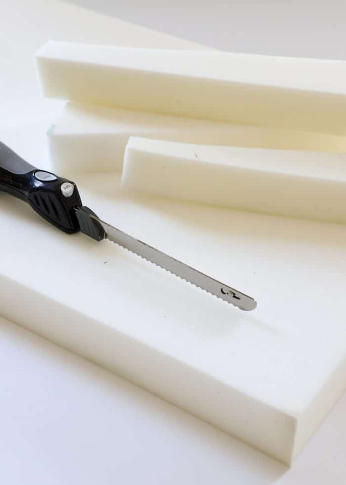 Electronic cutting knife shown on top of block of white upholstery foam