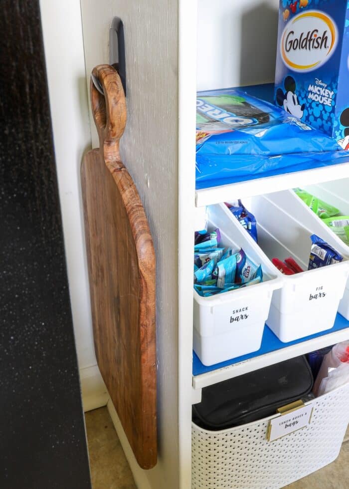 Charcuterie board on a black hook inside pantry