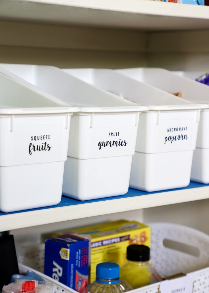 White book bins used to organize snacks in a pantry