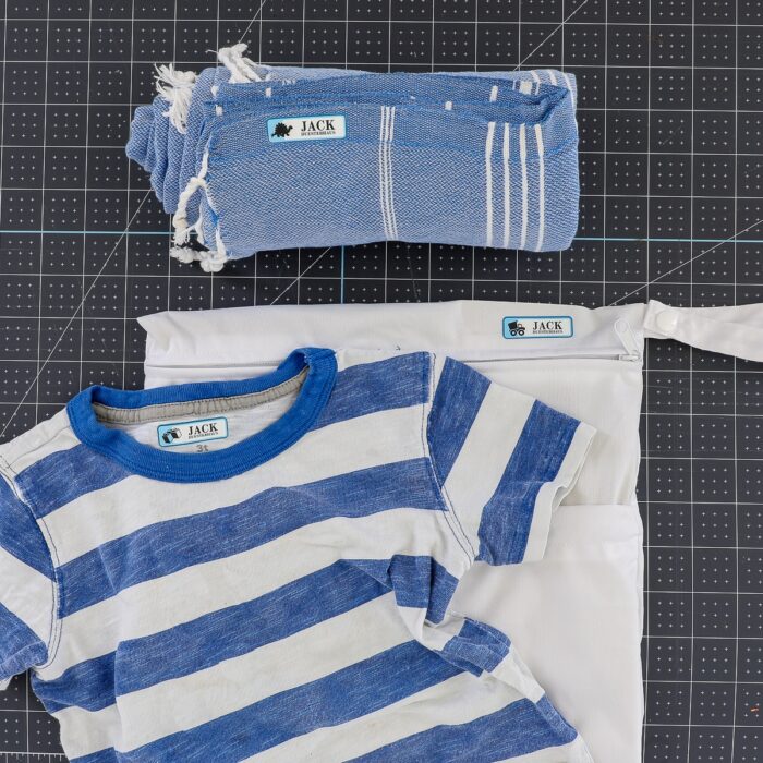 Blue kid's shirt, blue towel, and wet bag all shown with iron on labels