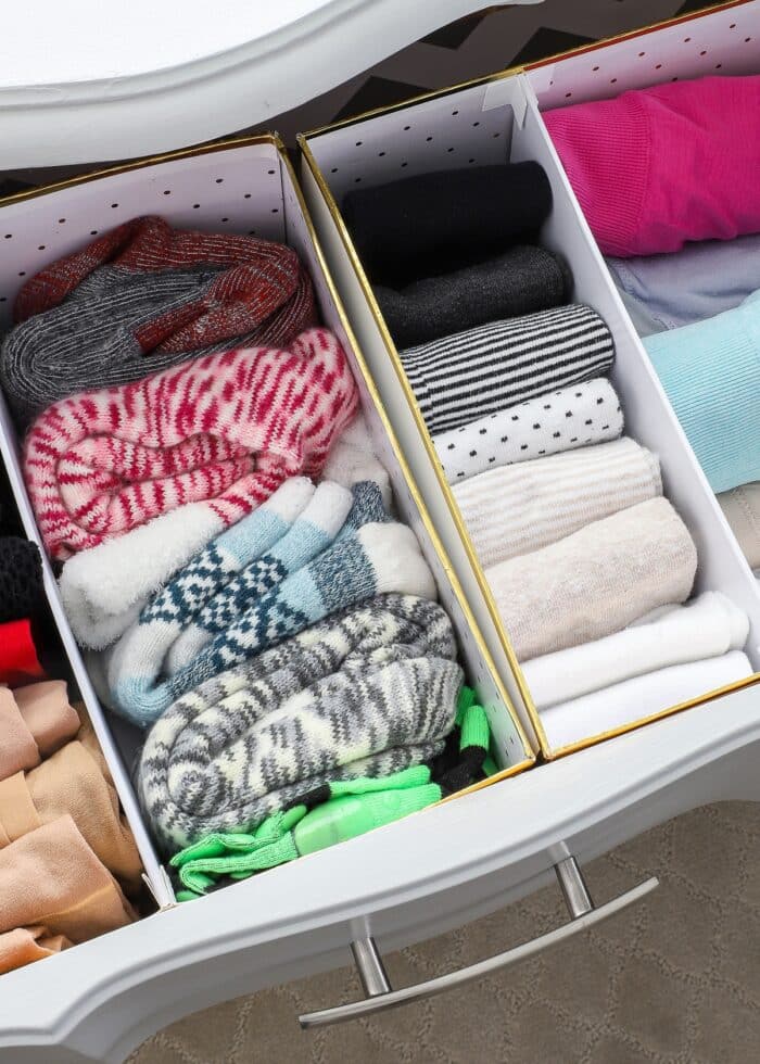 Socks organized in cardboard boxes inside a dresser drawer