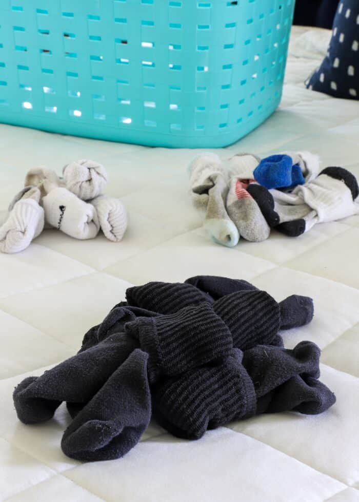Piles of socks on a bed with a white bedspread