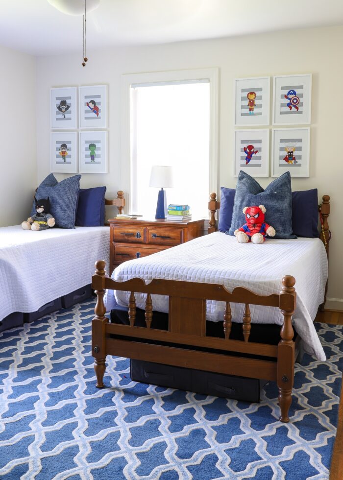 Blue and white kids bedroom with blue rug and wooden twin beds