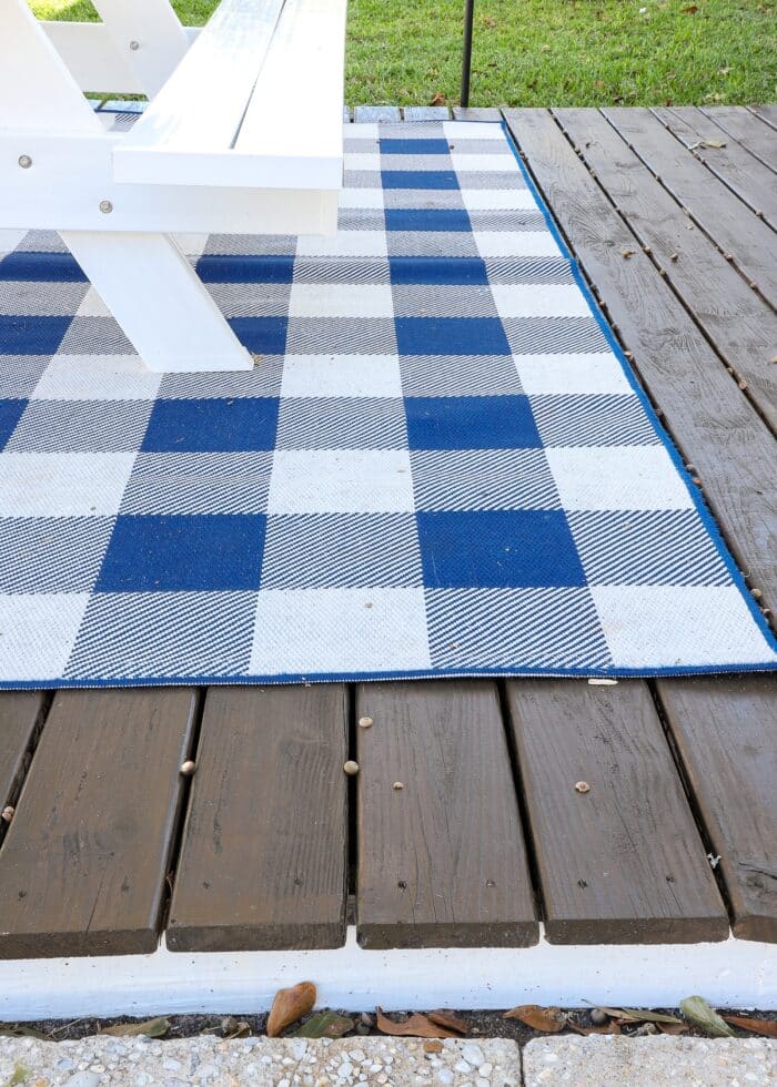 Blue and white checked rug on a white and wood deck