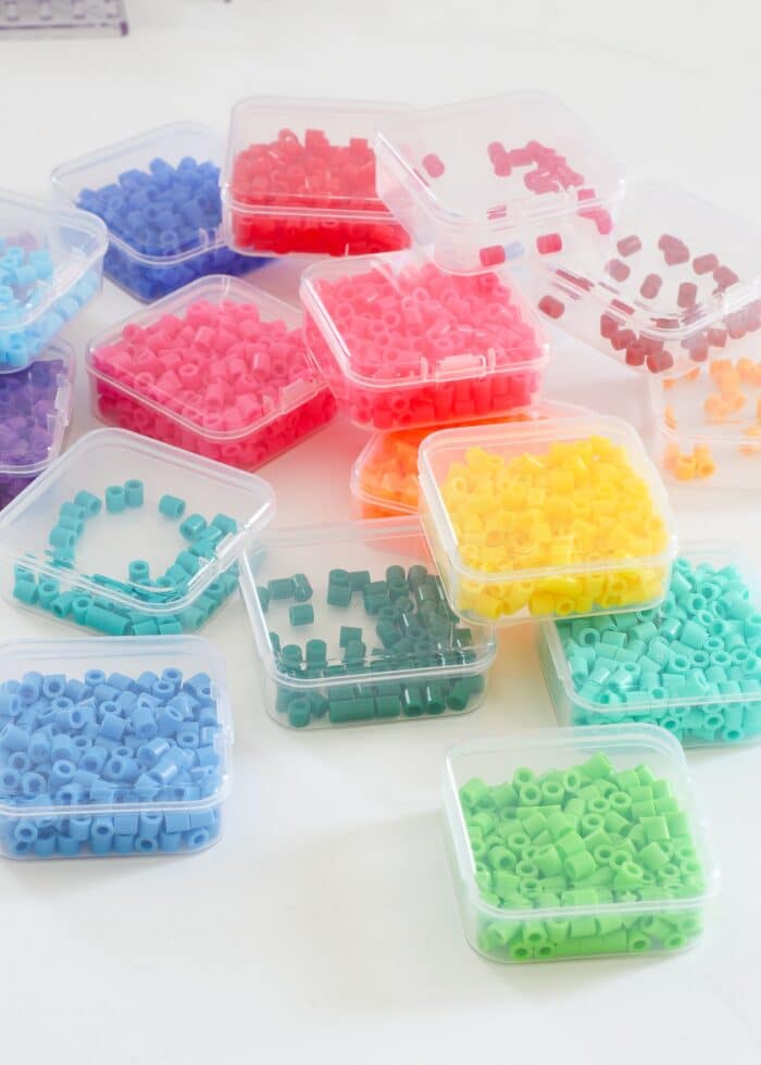 Perler beads sorted by color into small plastic boxes
