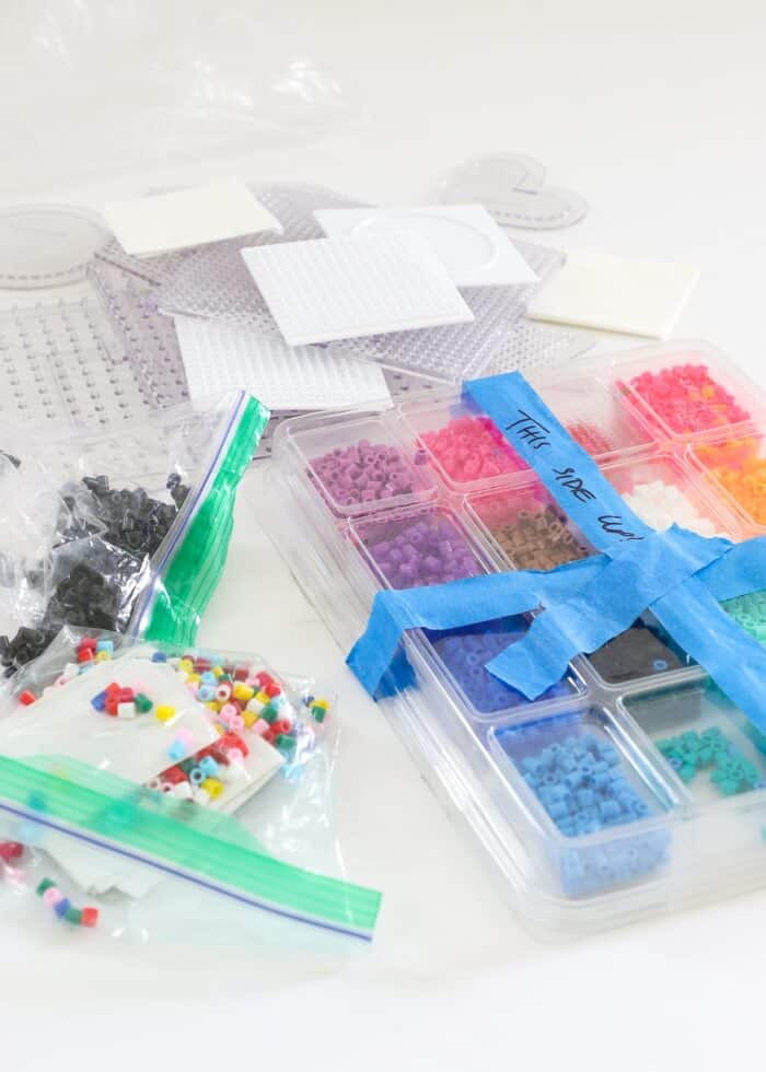A mess of perler bead supplies on a white table