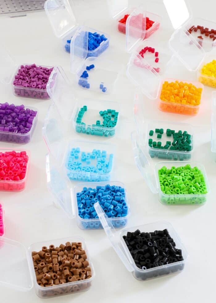Perler beads sorted by color into small plastic boxes