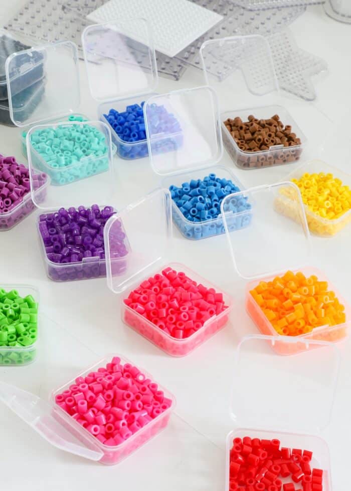 Different colors of perler beads sorted into small plastic boxes