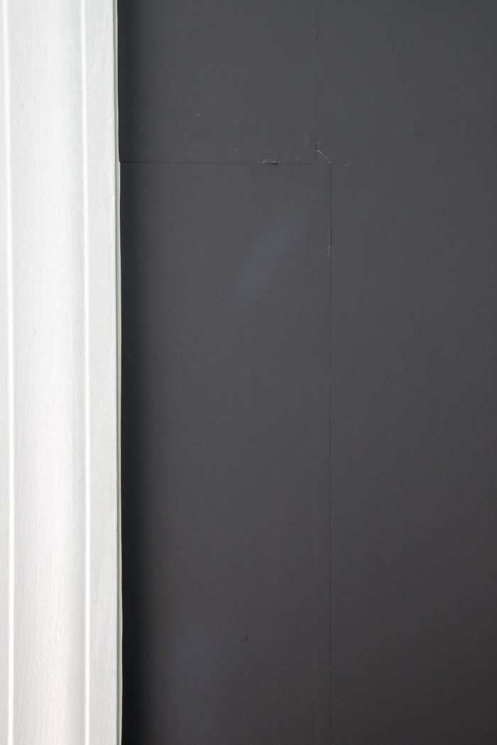 Solid grey wallpaper alongside bright white window trim