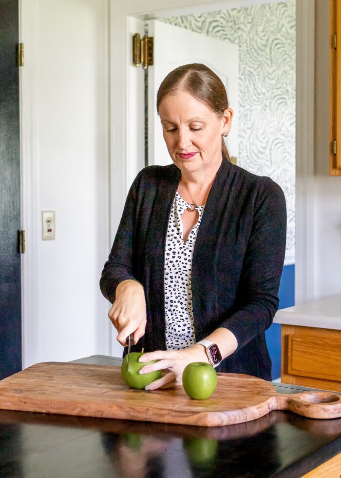 Megan slicing a green apple on a large cutting board