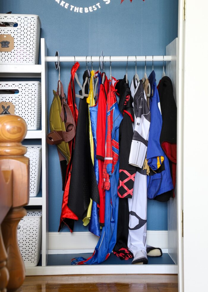 White costume rack holding super hero outfits on hangers