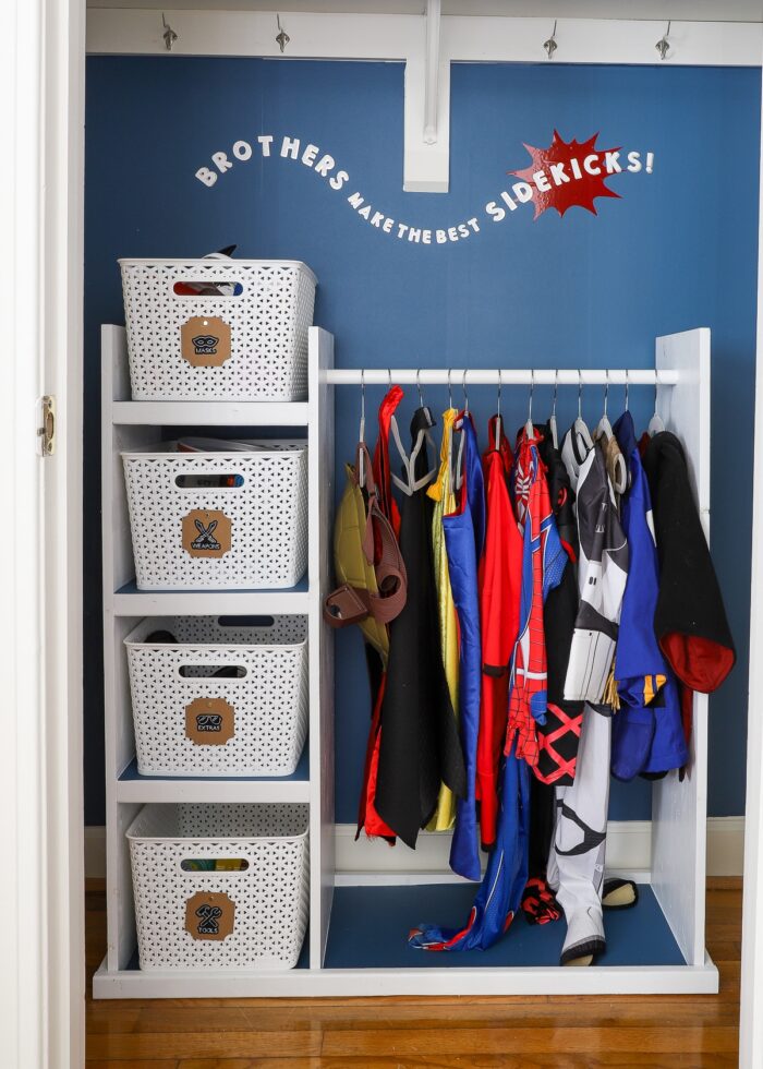 A white free-standing dress up rack sitting inside a kids' closet